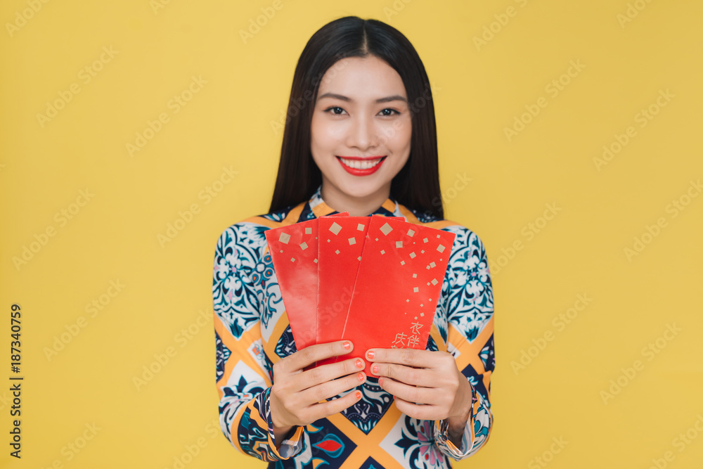 Attractive Vietnamese woman wearing traditional costume, isolated on yellow background