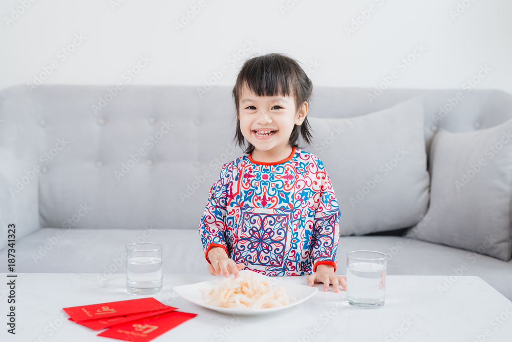 越南小女孩穿着敖岱传统服饰，在家庆祝新年。春节。