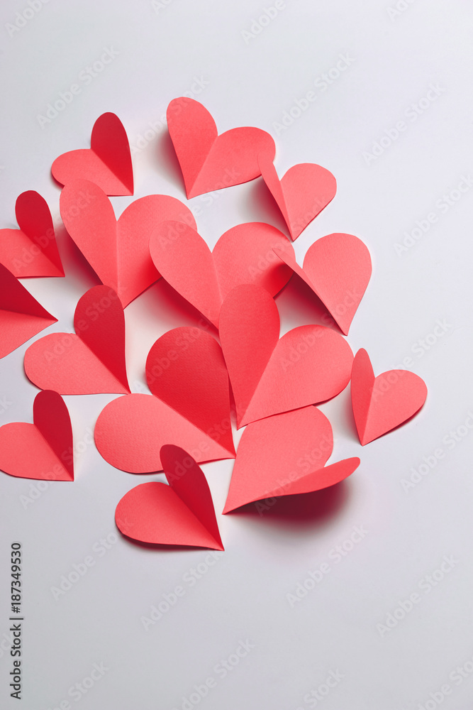 Beautiful pink paper hearts on white paper background