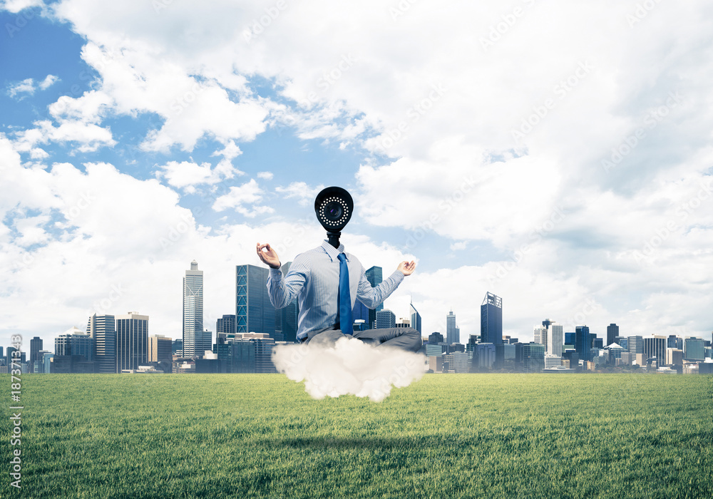 Camera headed man sitting in lotus pose on cloud against modern 