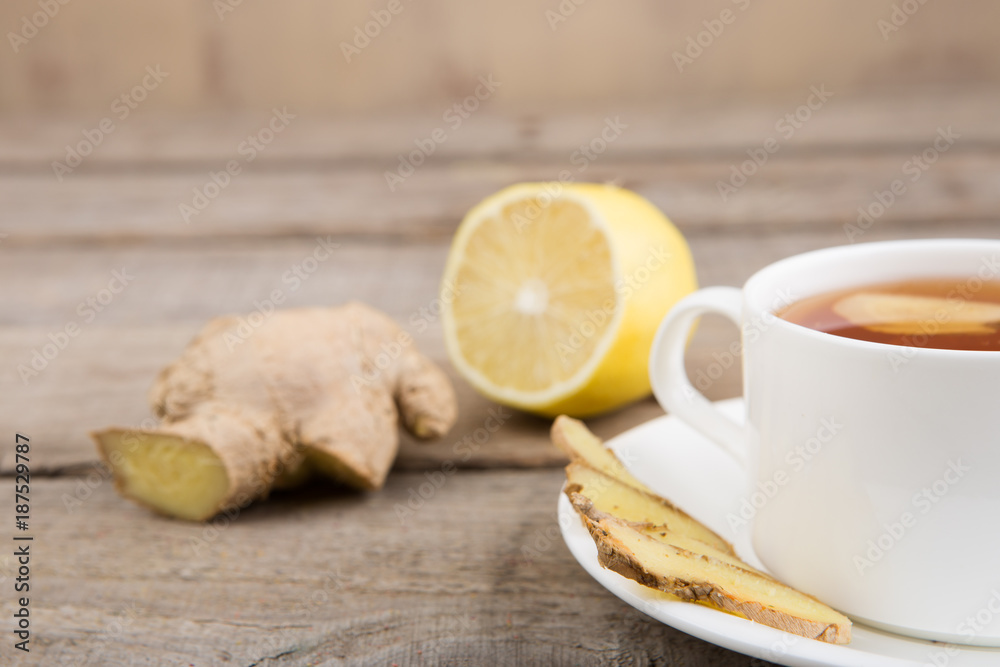 Ginger tea in a cup on wooden background