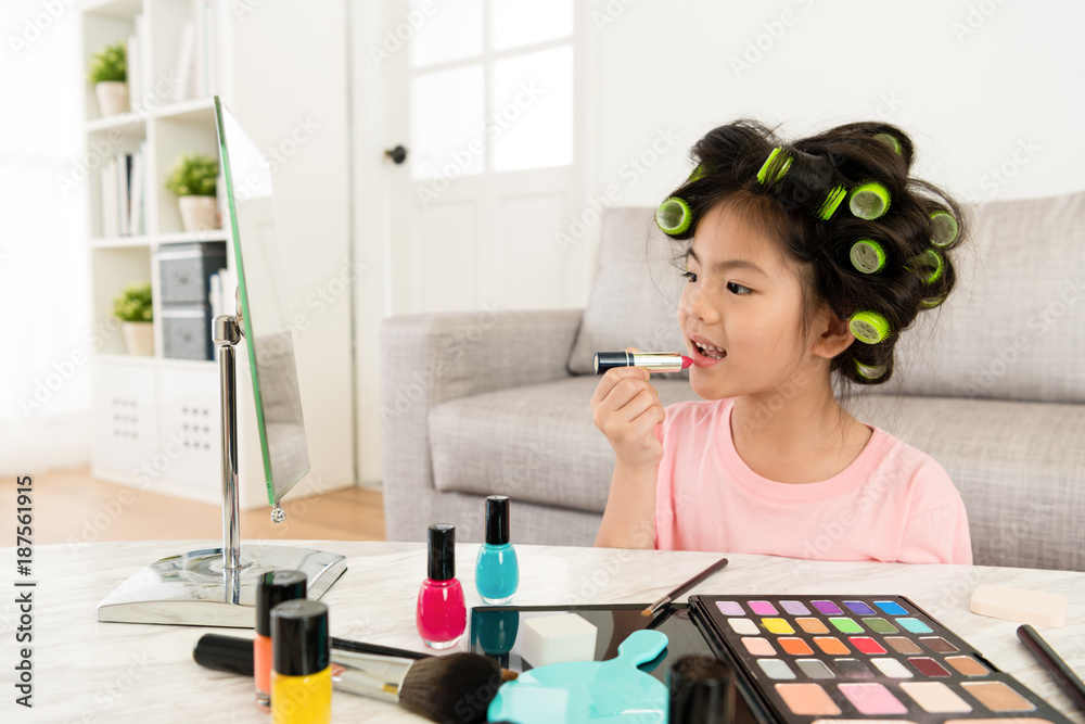 beautiful little girl kid using lipstick makeup