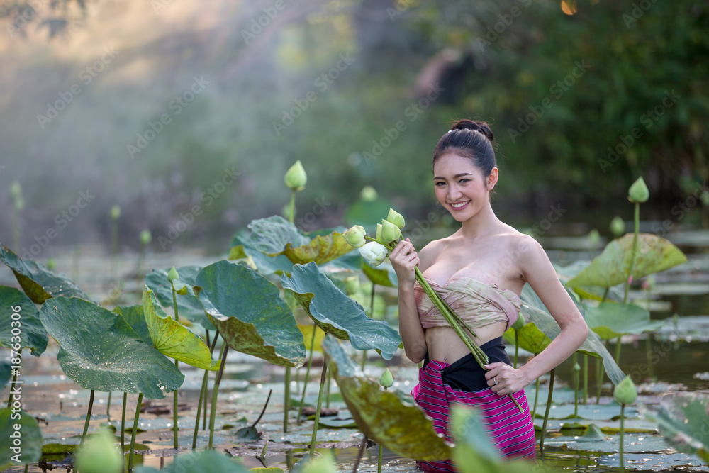 亚洲妇女在花园里收获莲花，