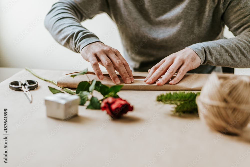 Male hands packing presents for a girl or a mother.