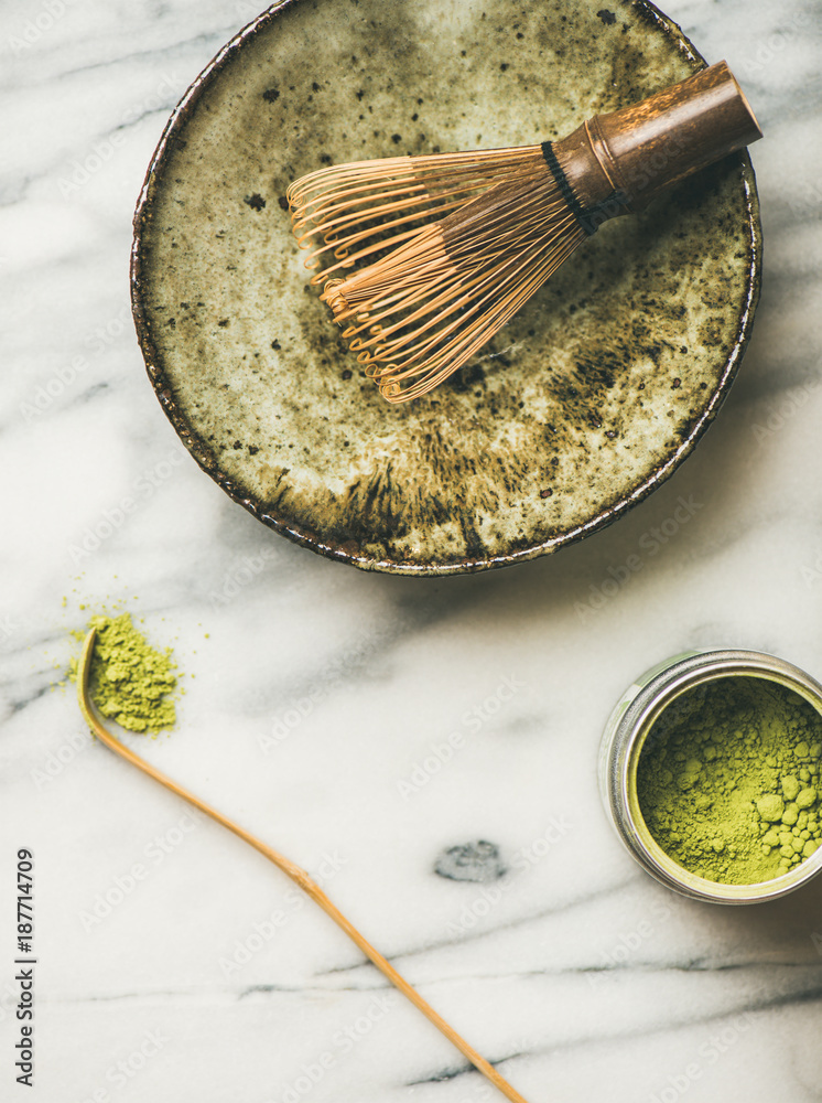 Flat-lay of Japanese tools and ceramic bowl for brewing matcha tea. Matcha powder in tin can, Chasha