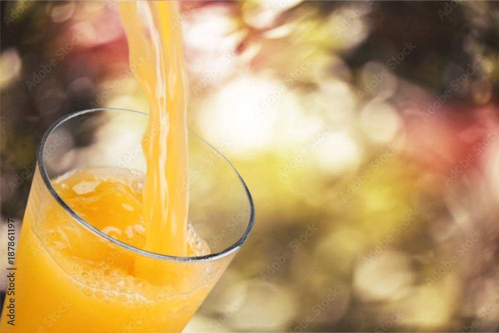 Orange juice pouring in glass