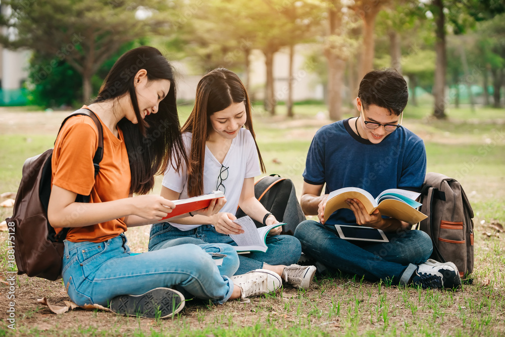 一群年轻或十几岁的亚洲学生在大学里微笑着读着书，看着ta