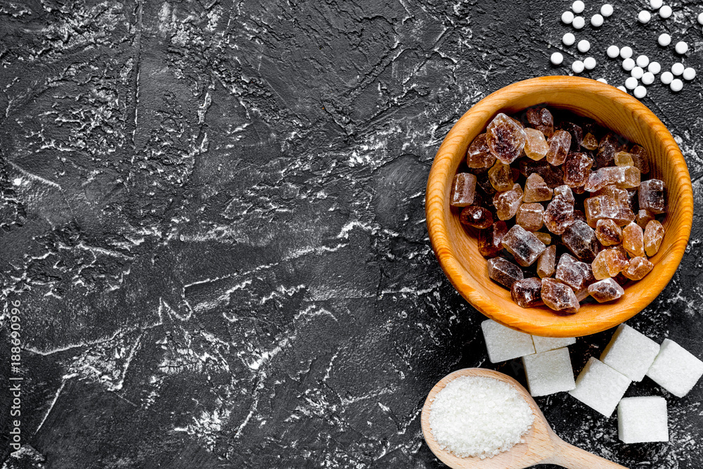 lumps of sugar in bowls on dark table background top view space 