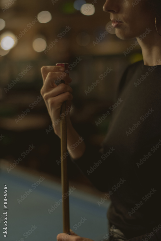 Woman playing pool at a bar