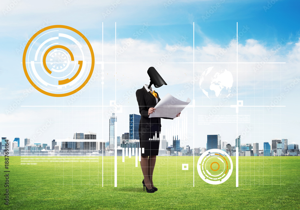 Camera headed woman standing on green grass against modern cityscape