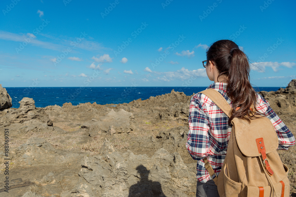 年轻漂亮的女性徒步旅行者的后视图照片