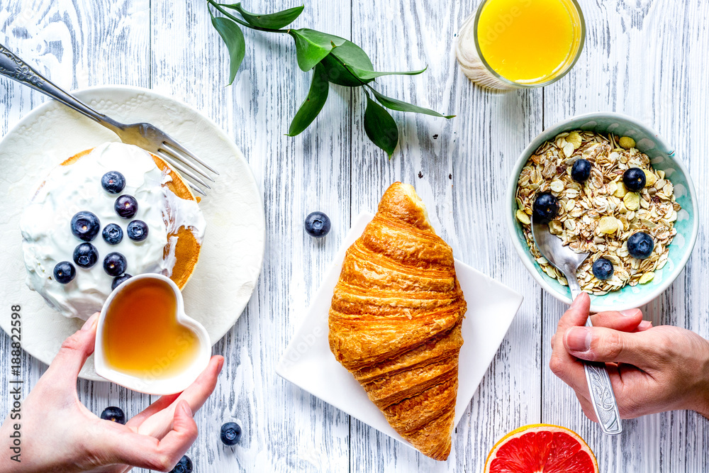 Breakfast concept with flowers on wooden background top view