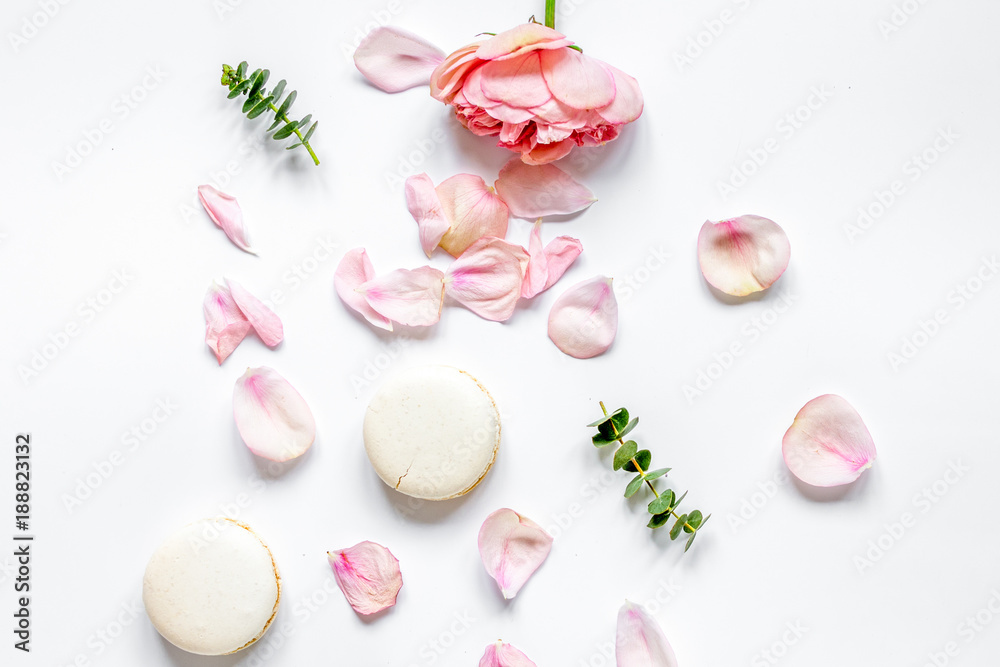 flat lay with petals and macaroons on white background top view