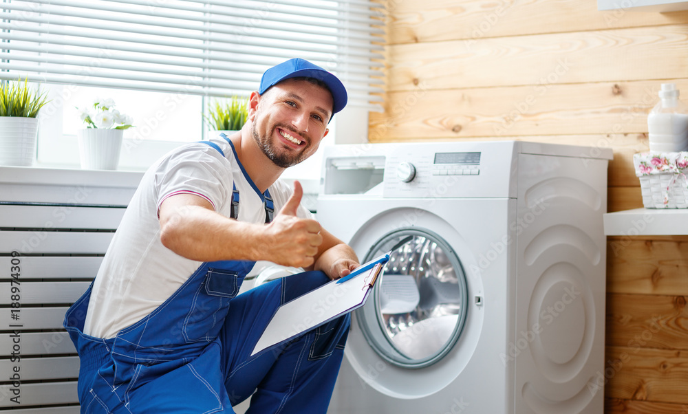 working man   plumber repairs  washing machine in   laundry