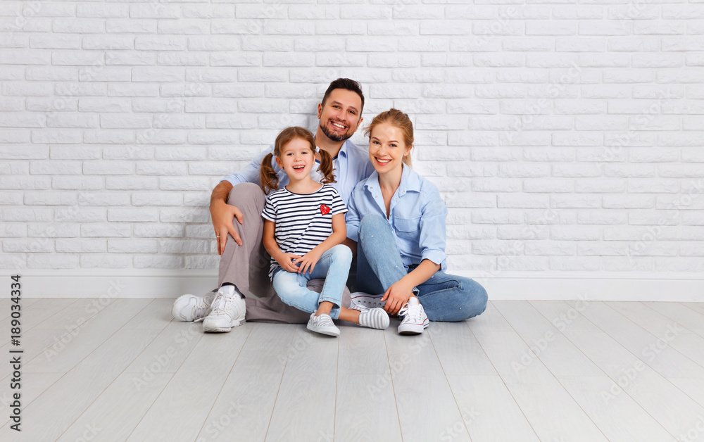 happy family mother father and child  near an empty brick wall