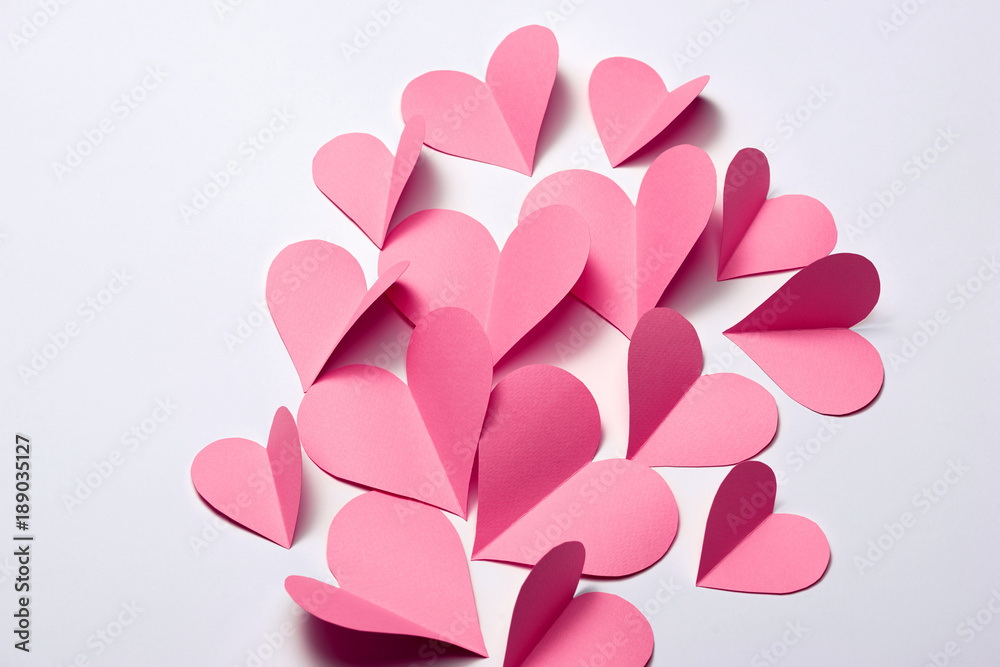 Beautiful pink paper hearts on white paper background