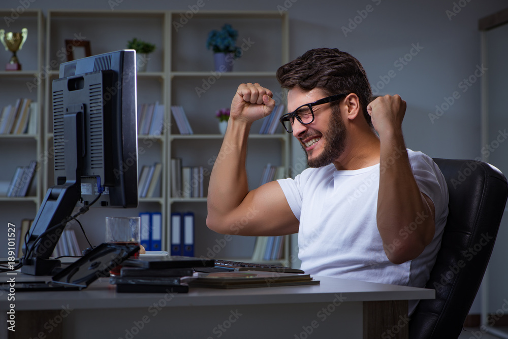 Young man staying late in office to do overtime work