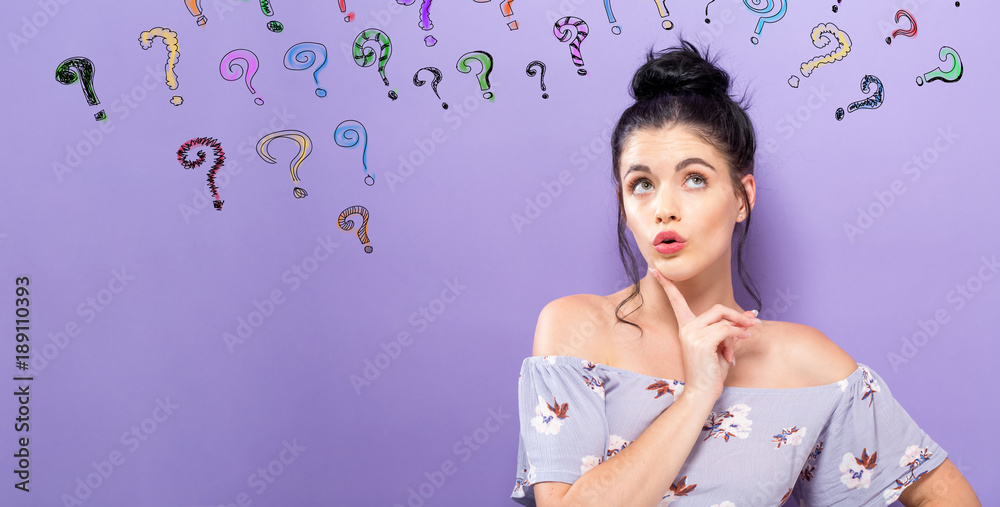 Young woman in a thoughtful pose with question marks