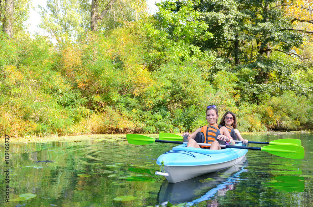 Family kayaking sport, mother and child paddling in kayak on river canoe tour, active autumn weekend