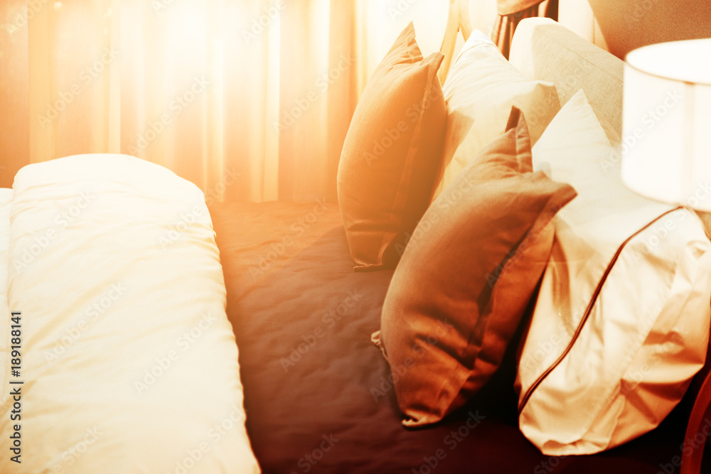 beautiful Bed maid-up with clean white pillows and bed sheets in beauty room. Close-up. Lens flair i