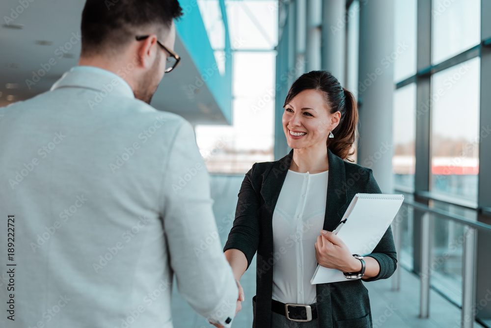 Business people handshake near the office building windows.