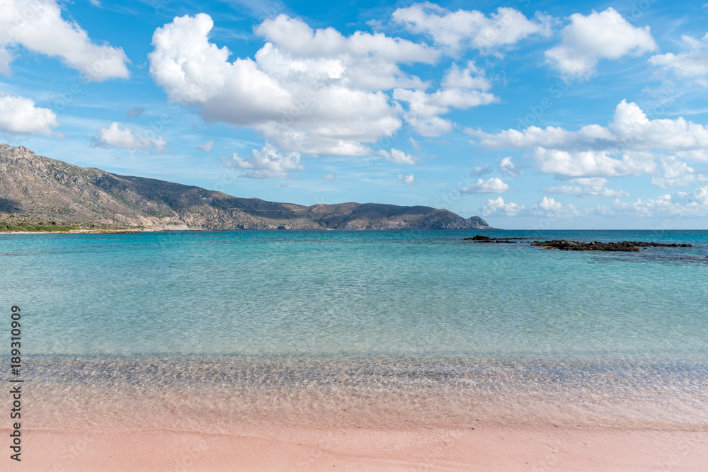 Soft waves of the sea on the pink sand and beautiful beach with cliffs.Coast of Crete island in Gree