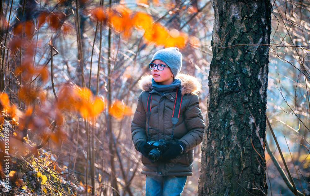 Boy with digital camera walking in the nature, hobby concept