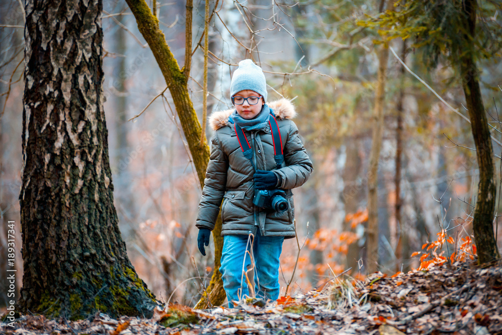 Boy with digital camera walking in the nature, hobby concept