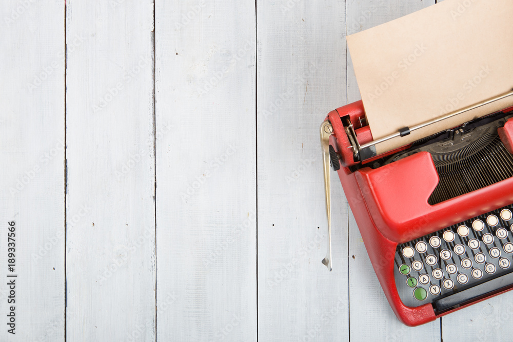 Writer or journalist workplace - vintage red typewriter on the white wooden desk