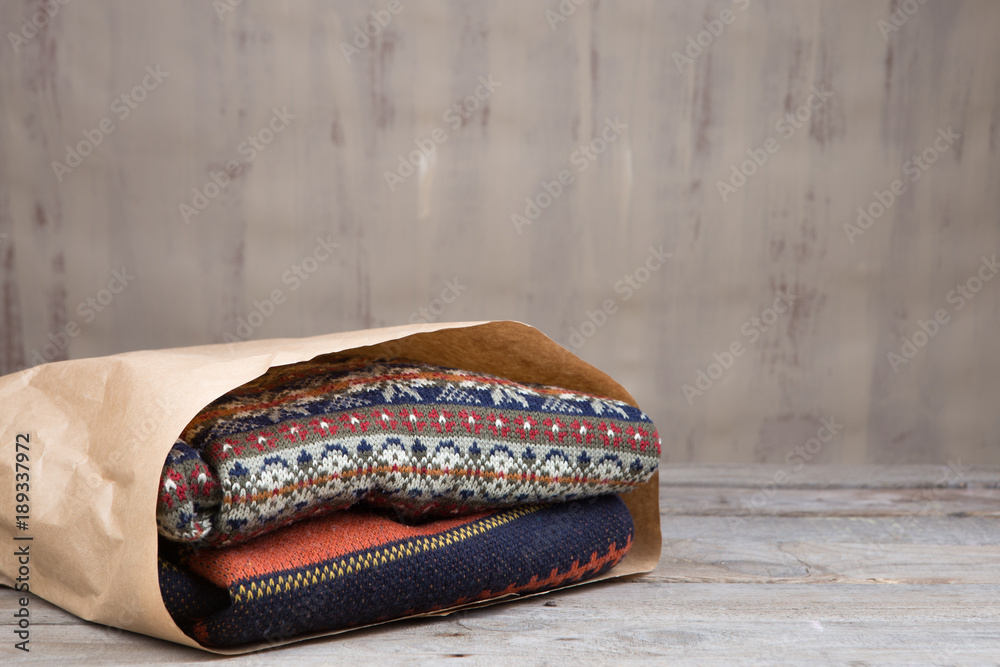 Pile of knitted winter sweaters on wooden background