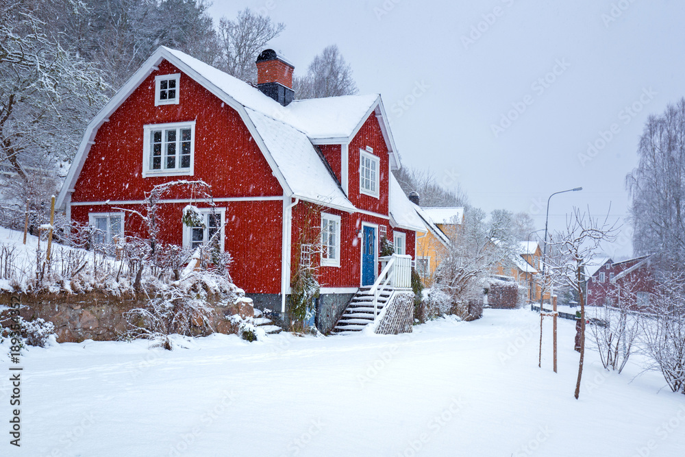 Winter scenery with red wooden house in Sweden