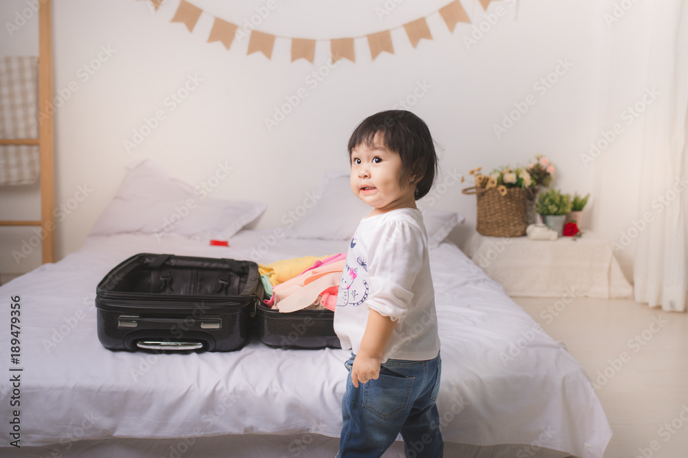 带着行李箱行李和衣服的女婴准备度假旅行