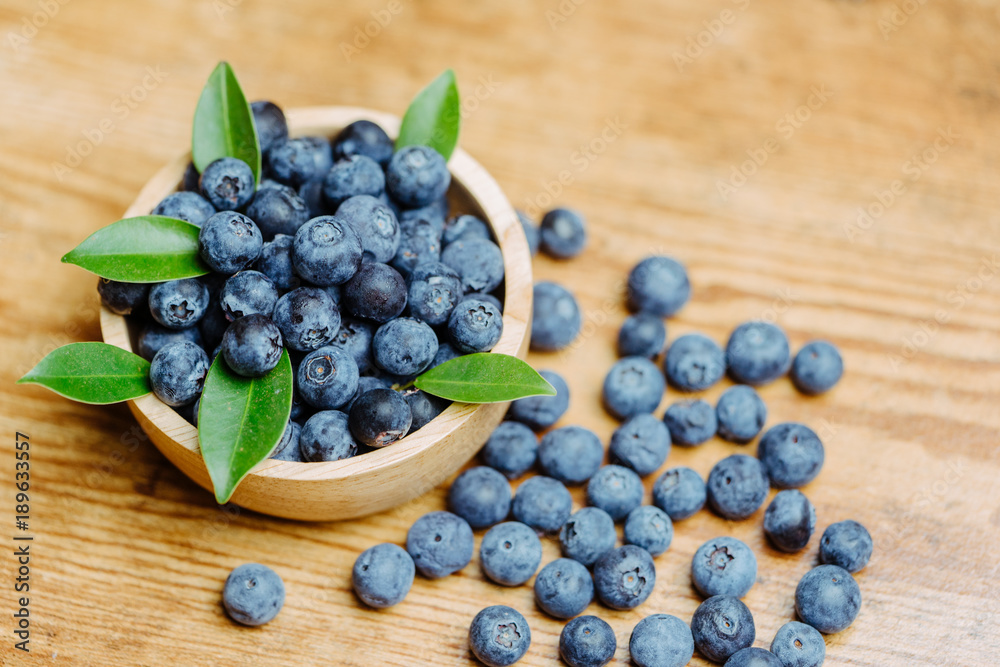 Freshly picked blueberries in wooden bowl.Bilberry on wooden Background. Blueberry antioxidant.Conce