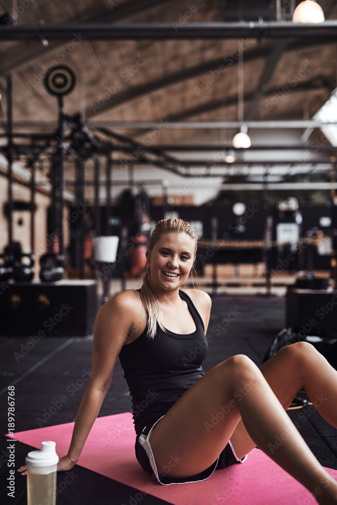 Smiling young woman taking a break from her gym workout