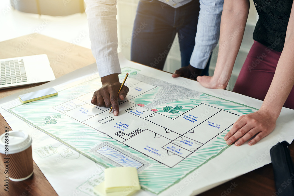 Architects discussing building plans at a desk in an office