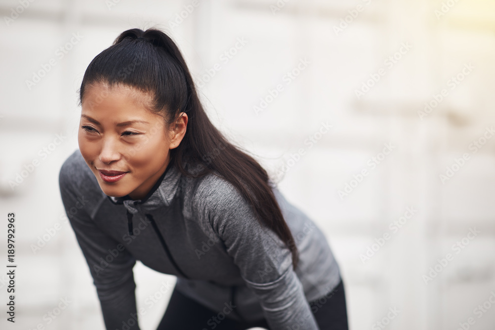 运动型年轻亚洲女性暂停跑步