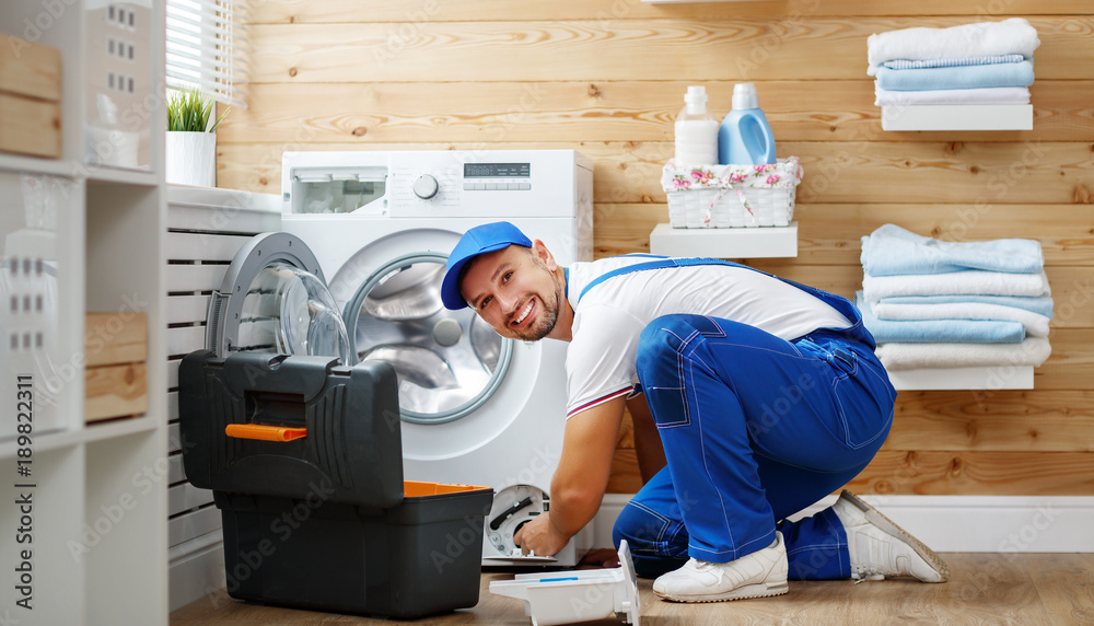 working man   plumber repairs  washing machine in   laundry