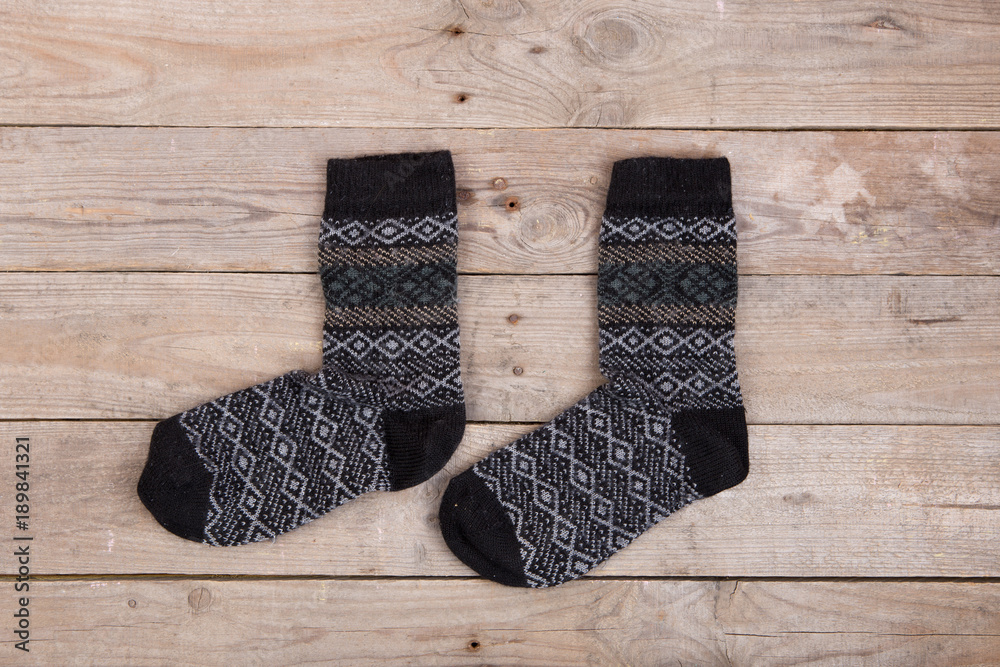 Knitted warm socks on the wooden background