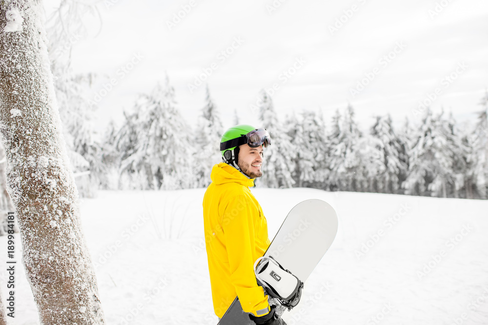 穿着冬季运动服的男子在雪山上滑雪板行走