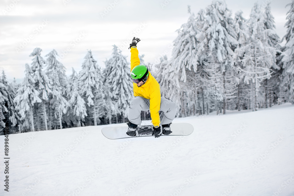 穿着五颜六色运动服的男子在有美丽树木的雪山上滑雪