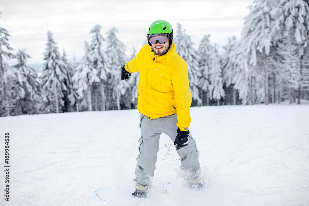 穿着五颜六色运动服的男子在有美丽树木的雪山上滑雪