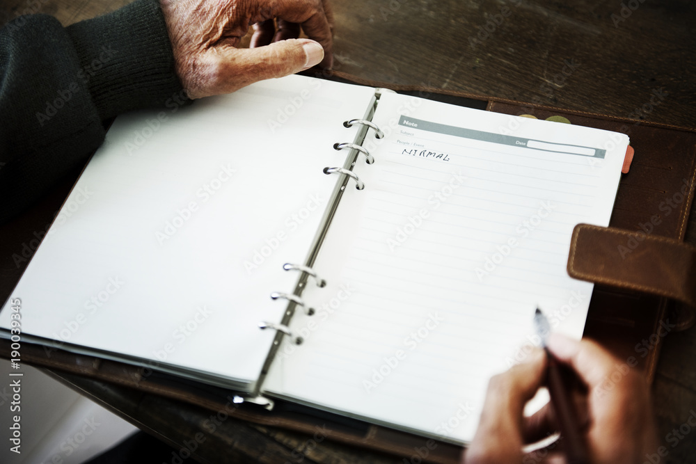 Senior person's hand writing a journal