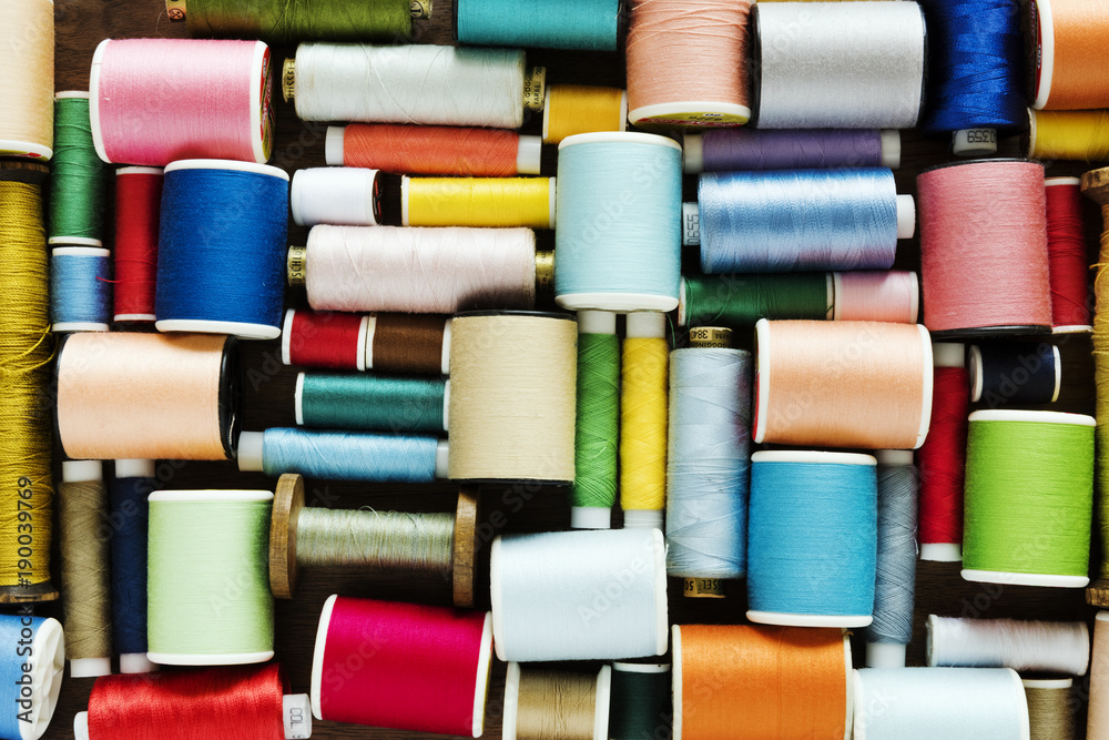 Colorful sewing threads background closeup