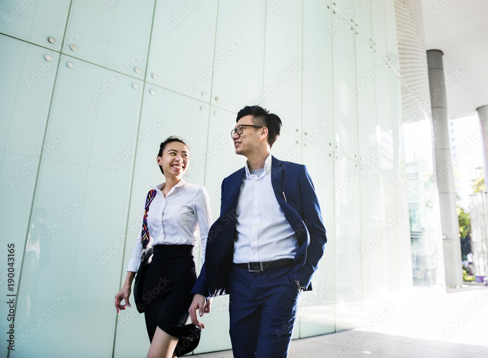 Asian business people discussing while walking