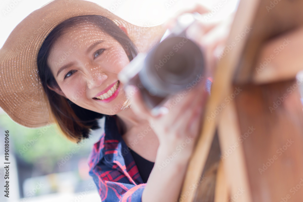 亚洲美女休闲装配相机和以古城为背景的旅行用品