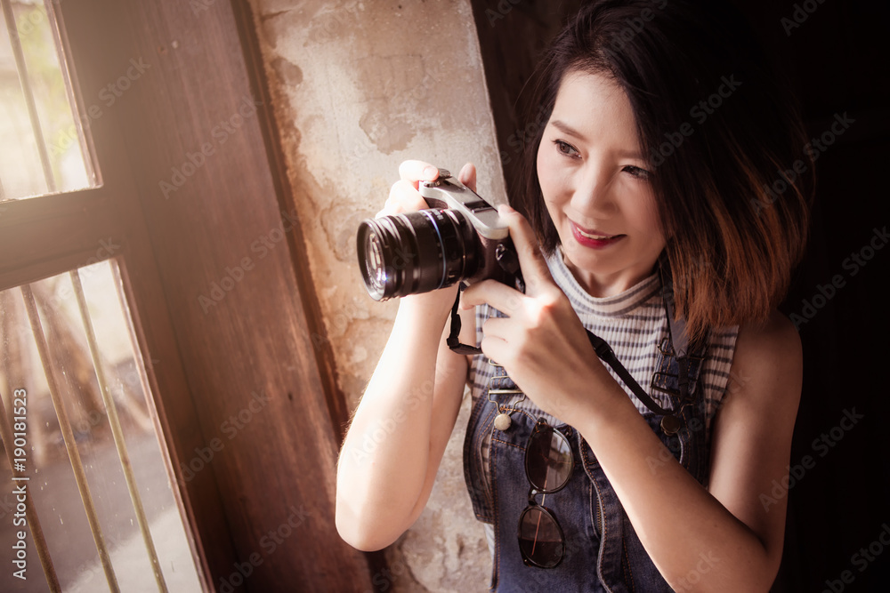 亚洲美女休闲装配相机和以古城为背景的旅行用品