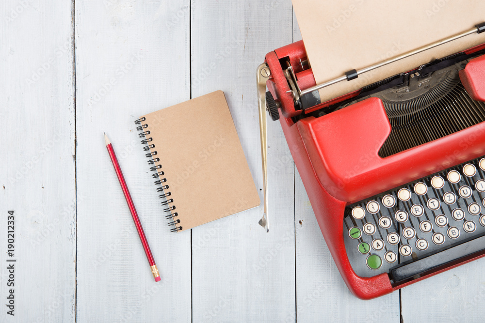 Writer or journalist workplace - vintage red typewriter on the white wooden desk