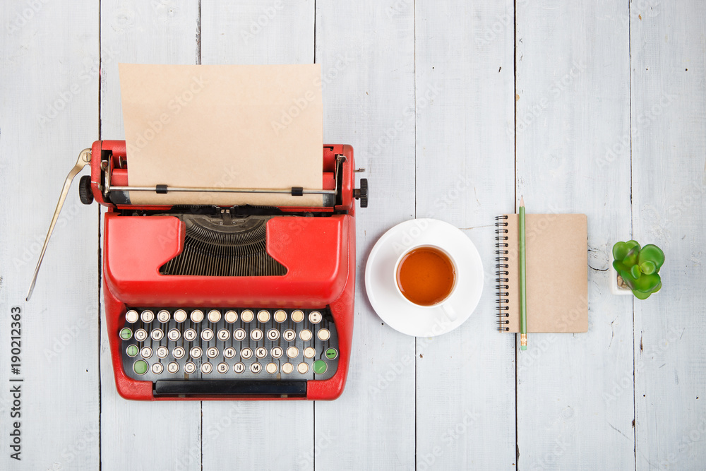 Writer or journalist workplace - vintage red typewriter on the white wooden desk