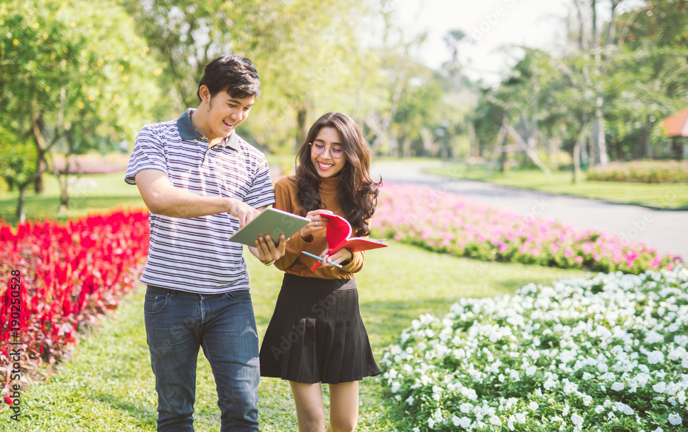 happy students walking and talking each other in a campus at park with a warm light