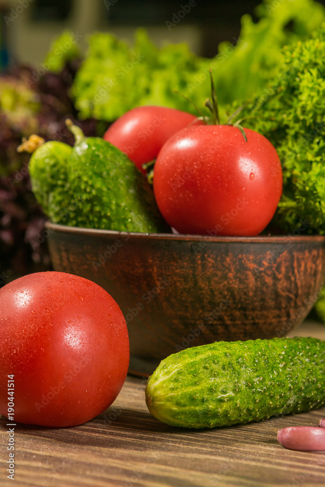 Fresh vegetables in a ceramic bowl on a rustic wooden table. The concept of a healthy diet